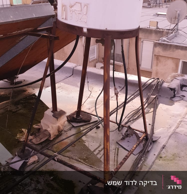 דוד שמש על גג עם צינורות חלודים